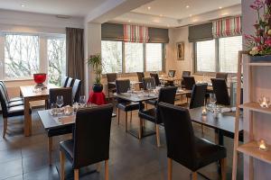 jadalnia ze stołami, krzesłami i oknami w obiekcie Le Leman Hotel w mieście Vevey