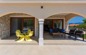 un patio avec des chaises jaunes et une table dans l'établissement Lovely Home In Sveti Viddobrinjski With Wifi, à Gostinjac 35 autres photos