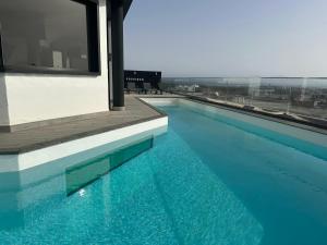 basen z niebieską wodą w budynku w obiekcie Villa Poseidon Corralejo with Private Heated Pool, Sauna and Stunning Volcano Views by Amazzzing Travel w Corralejo