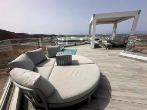 biała kanapa siedząca na balkonie w obiekcie Villa Poseidon Corralejo with Private Heated Pool, Sauna and Stunning Volcano Views by Amazzzing Travel w Corralejo
