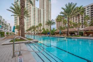 Una gran piscina con palmeras y edificios. en 1801 Sapphire Beachfront 3 Bedroom Condo, en South Padre Island