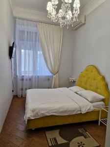 a bedroom with a large bed and a chandelier at Затишна квартира на Майдані Незалежності in Kyiv