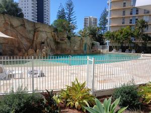 a fence around a swimming pool in a city at Wings 2 Bedroom Apartment in Gold Coast