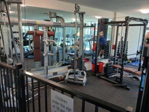 a woman in a gym with several tread machines at Wings 2 Bedroom Apartment in Gold Coast