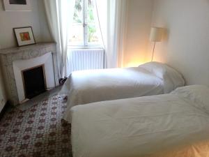 カンヌにある16 Avenue Marechal Gallieniのベッド2台 暖炉付きのホテルルーム内
