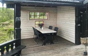 a table and chairs on the deck of a cabin at 4 Bedroom Beautiful Home In Engerdal in Nymoen