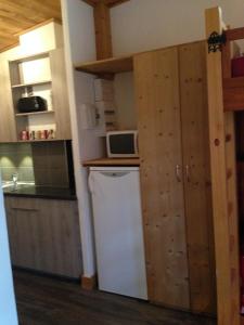 a small kitchen with a refrigerator and a microwave at Spacieux Studio - Les chaudes Almes in Tignes