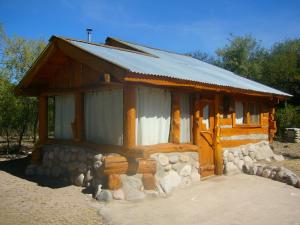 Cabaña de madera pequeña con pared de piedra en Complejo Casas de Campo, en San Marcos Sierras