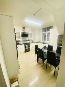 a kitchen with a glass table and chairs in it at London Stays Whitechapel in London +19 photos