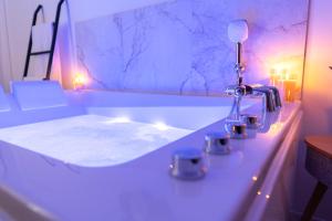 a white bathroom with a sink with lights on it at Riviera Bliss in Nice