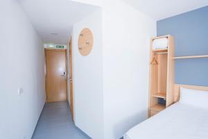 a small room with a bed and a door at Alda Egues Rooms in Gorraiz