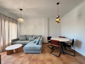 ein Wohnzimmer mit Couch und Tisch in der Unterkunft Balnea Experiences - Apartamentos con Piscina Exterior, Jacuzzi y Gimnasio in Archena