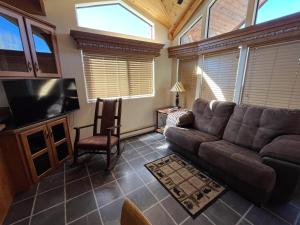 a living room with a couch and a flat screen tv at Cabin 41 in Almont