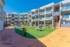 apartamentowiec z trawnikiem przed nim w obiekcie Coral Sun Corralejo iRent Fuerteventura w Corralejo