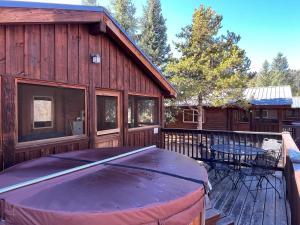 a wooden cabin with a hot tub on a deck at Cabin 20 in Almont