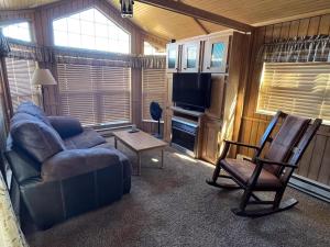 a living room with a couch and a chair at Cabin 61 in Almont