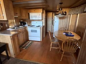 a kitchen with a table and a white stove top oven at Cabin 61 in Almont +16 photos