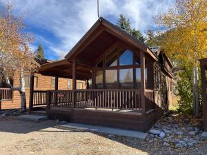 a wooden cabin with a large porch with glass at Cabin 40 in Almont