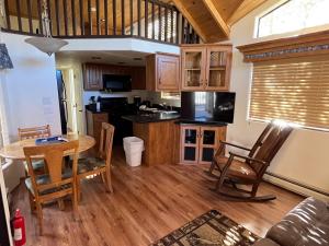 a kitchen and dining room with a table and chairs at Cabin 40 in Almont +19 photos