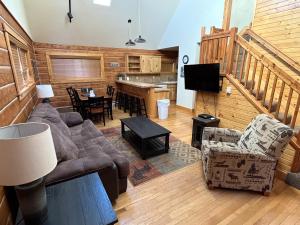a living room with a couch and a table at Cabin 28 in Almont