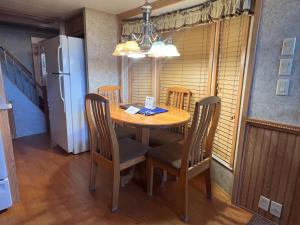 a dining room table with chairs and a refrigerator at Cabin 63 in Almont +8 photos
