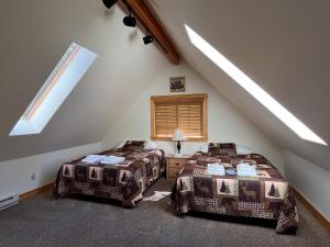 two beds in a room with a attic at Cabin 28 in Almont