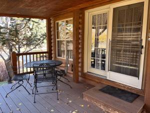 a porch of a house with a table and chairs at Cabin 62 in Almont +14 photos