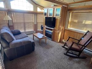 a living room with a couch and a tv at Cabin 62 in Almont