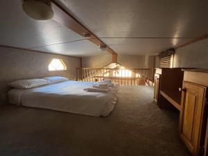 a bedroom with a large bed with white sheets at Cabin 62 in Almont
