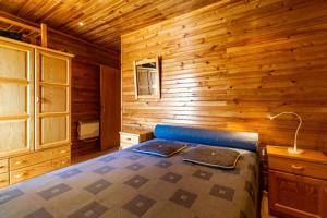 a bedroom with a bed in a wooden cabin at Estrela Prime Stays in Penhas da Saúde