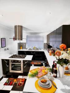 a kitchen with a table with plates of food on it at Charming 3-bedroom House with Garden in Portsmouth, Close Parking, Train Station & Gunwharf in Portsmouth