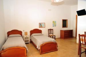 une chambre avec deux lits et une table et des chaises dans l'établissement Agriturismo Il Piccolo Lago, à Otrante