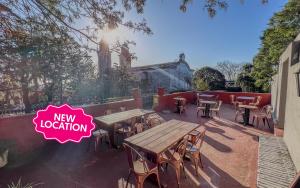 a group of tables and chairs on a patio at Viajero Colonia Hostel in Colonia del Sacramento