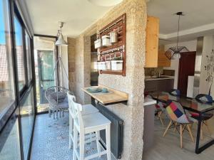 a kitchen and living room with a table and chairs at CASA DOS PEIXIÑOS Pontesampaio in Pontevedra