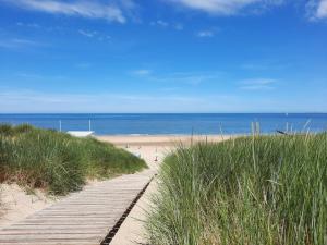 einen Weg zum Strand mit dem Ozean im Hintergrund in der Unterkunft De Vlier 8* in Nieuwvliet