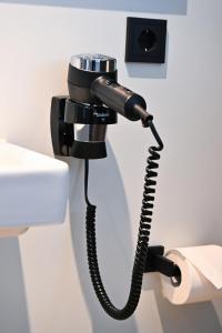 a black phone hanging on a bathroom wall at Roatel Gau-Bickelheim A61 my-roatel-com in Gau-Bickelheim +9 photos