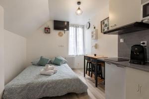 a bedroom with a bed with a stuffed animal on it at Charmant studio proche de toutes commodités in Saint-Quentin