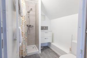 a white bathroom with a shower and a toilet at Charmant studio proche de toutes commodités in Saint-Quentin