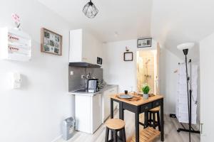 a small kitchen with a table in a room at Charmant studio proche de toutes commodités in Saint-Quentin +4 photos