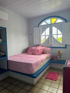 ein Schlafzimmer mit einem Bett in einem Zimmer mit einem Fenster in der Unterkunft Carneiros House in Praia dos Carneiros