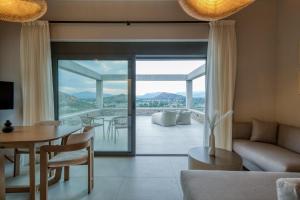 a living room with a couch and a table and a glass door at Doceo Refined Living in Nafplio