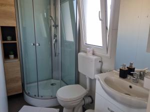 een badkamer met douche, toilet en wastafel bij Mobile Home Elica, Pirovac in Pirovac