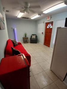 een woonkamer met een rode bank en een deur bij 4 BR 2 BA Near the Beach and Intracoastal Walk to everything in Riviera Beach