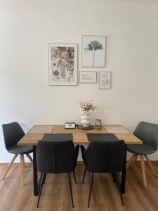 tavolo da pranzo con 4 sedie e vaso con fiori di Sun & Moon Apartments Erfurt a Erfurt Altre 17 foto