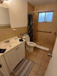 een badkamer met een wastafel, een toilet en een douche bij 4 BR 2 BA Near the Beach and Intracoastal Walk to everything in Riviera Beach