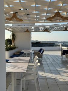 a patio with white tables and chairs on a roof at Misk Villa - Boutique Hotel & Spa in Sidi Bou Saïd