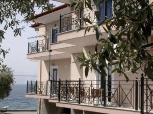 a building with balconies next to the water at Lihas Studios in Agios Georgios