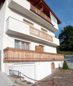 a white house with a balcony and a garage at Cà sul dos in Trento