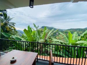 a balcony with a table and a view of the mountains at Wood Heart in Ella
