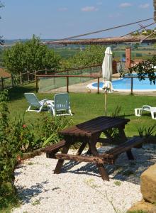 ein Picknicktisch und zwei Stühle neben einem Pool in der Unterkunft La Pietraia in Panicale